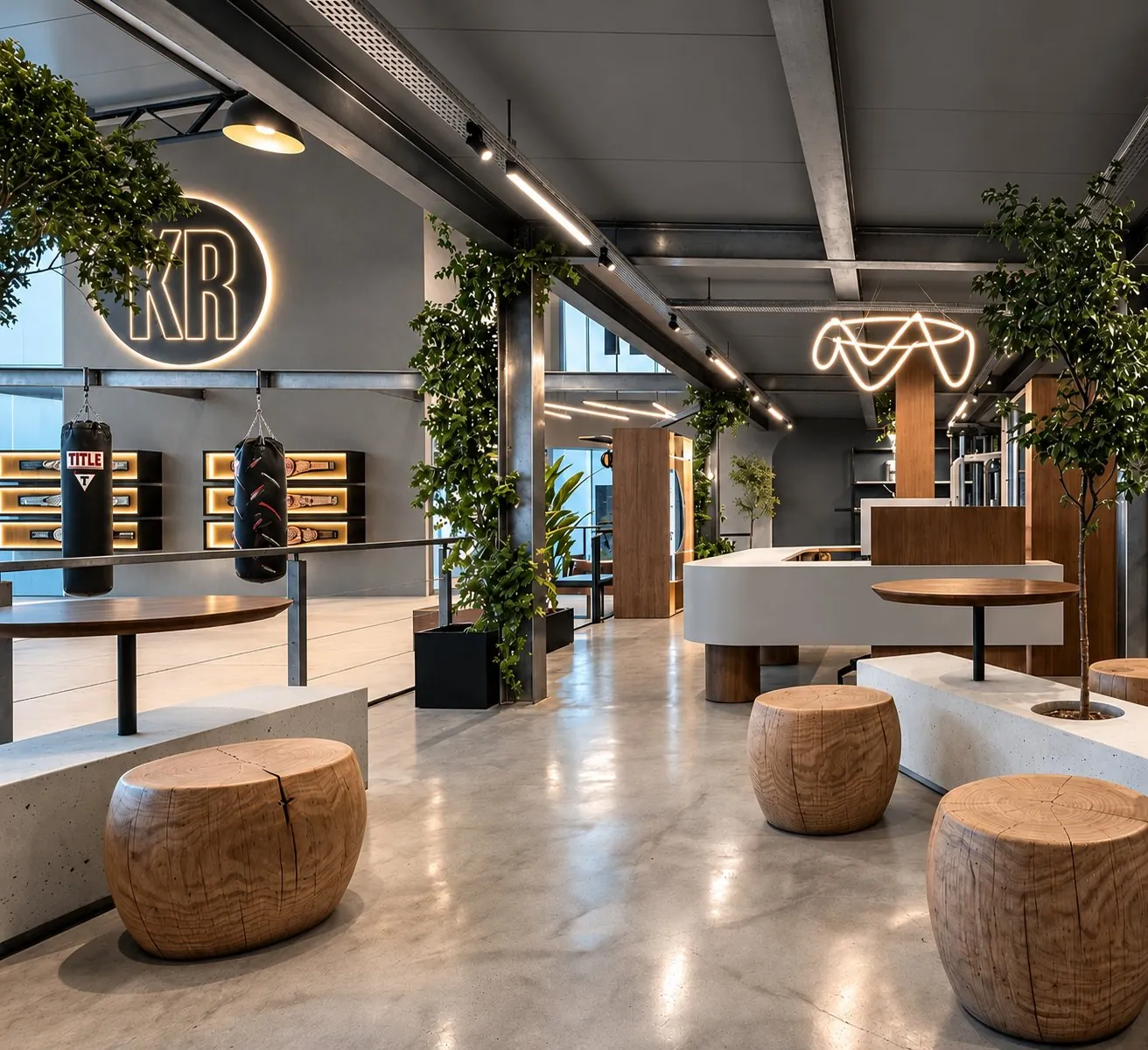 Espaço de convivência da KR com bancos de madeira, plantas e o logo KR iluminado na parede